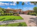 Inviting single-story home featuring a red brick drive, barrel tile roof and manicured lawn at 15110 Kestrelglen Way, Lithia, FL 33547