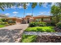 Beautiful single-story home featuring a red brick drive, barrel tile roof and manicured lawn at 15110 Kestrelglen Way, Lithia, FL 33547