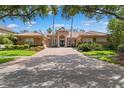 Beautiful single-story home featuring a red brick drive, barrel tile roof and lush landscaping at 15110 Kestrelglen Way, Lithia, FL 33547