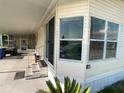 Inviting exterior showcasing large windows, a covered carport and a well-maintained lawn, enhancing the property's charm at 1710 7Th Sw St # 85, Ruskin, FL 33570