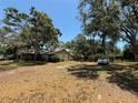 Wide view of a backyard with mature trees and a parked car at 2033 Aaron Pl, Clearwater, FL 33760