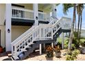 Inviting entrance staircase with white railings, dark grey steps and decorative potted plants at 24197 Treasure Island Blvd., Punta Gorda, FL 33955