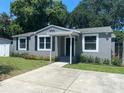 Charming single-story home with well-maintained landscaping, gray exterior, and a concrete driveway and carport at 2709 S Manhattan Ave, Tampa, FL 33629