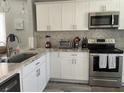Bright kitchen featuring white cabinetry, marble-style countertops, and stainless steel appliances at 2714 60Th Avenue W Ter # 12D, Bradenton, FL 34207