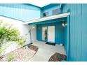 Inviting front porch with turquoise painted walls, decorative foliage, and a tiled walkway at 34507 Cedarfield Dr, Dade City, FL 33523