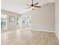 Bright and airy living room with vaulted ceiling, light wood flooring, and French doors to another room at 4655 Wallingford Ct # 4655, New Port Richey, FL 34655