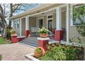 Inviting front porch with swing, brick accents, and decorative plants creating a cozy and welcoming entrance at 4913 N Central Ave, Tampa, FL 33603