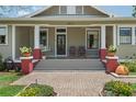 Inviting front porch with swing, brick accents, and decorative plants creating a cozy and welcoming entrance at 4913 N Central Ave, Tampa, FL 33603