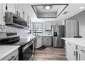 Modern kitchen featuring stainless steel appliances, light gray cabinetry, and a stylish backsplash at 609 Lively Dr # B, Sun City Center, FL 33573