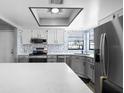 Kitchen showcasing stainless steel appliances, gray cabinets, and large island with white marble countertops at 609 Lively Dr # B, Sun City Center, FL 33573