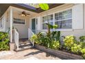 Inviting front porch with lush tropical landscaping, a charming railing, and a welcoming entrance at 6114 7Th S Ave, Gulfport, FL 33707