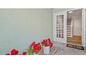 Inviting entrance with red flowers and a glimpse of the bright interior staircase at 616 Garland Cir, Indian Rocks Beach, FL 33785