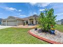Charming home exterior featuring manicured lawn, colorful flower beds, and inviting entryway at 6425 Clair Shore Dr, Apollo Beach, FL 33572