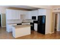 Modern kitchen featuring white cabinets, granite countertops, stainless steel appliances, and stylish island at 6434 Old Main St, New Port Richey, FL 34653