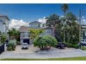 Charming multi-story home with mature trees, a driveway, and an attached garage at 803 Harbor Dr, Belleair Beach, FL 33786