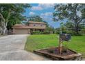 Inviting two-story home with lush landscaping, large trees, and a well-kept lawn creating a serene setting at 9465 126Th Ave, Largo, FL 33773