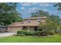 Beautifully landscaped two-story home with a brick accents, and a well-manicured lawn and garden at 9465 126Th Ave, Largo, FL 33773