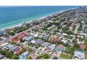 Stunning aerial view of a beach house with ocean views and lush tropical landscaping at 101 8Th St, Belleair Beach, FL 33786