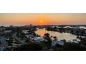 Stunning sunset view of waterfront homes and calm canal reflecting the sunlight at 10355 Paradise Blvd # 1003, Treasure Island, FL 33706