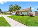 Landscaped side yard with lush green lawn and privacy fence and a 2 car garage at 12470 93Rd St, Largo, FL 33773