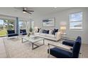 Bright living room with neutral walls, large windows, and stylish furnishings at 12697 Achasta Blvd, Hudson, FL 34669