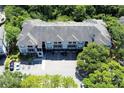 Aerial view showcasing the apartment building nestled in a lush, green environment with ample parking at 13235 Sanctuary Cove Dr # 201, Temple Terrace, FL 33637