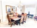 Elegant dining room features a decorative chandelier, a long dining table, and ornate chairs set on a neutral carpet at 14711 Potterton Cir, Hudson, FL 34667