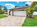 Spacious two-car garage with a brick driveway, set against a well-manicured lawn and mature landscaping at 15108 Springview St, Tampa, FL 33624