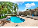 Refreshing backyard pool surrounded by a patterned concrete patio and lush greenery for ultimate relaxation at 15108 Springview St, Tampa, FL 33624