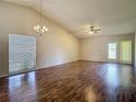 Bright living room features vaulted ceilings, a chandelier, a ceiling fan, and wood flooring at 1517 Gunsmith Dr, Lutz, FL 33559