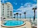Inviting pool area with ample lounge chairs, tables and beach view from the lovely condominium at 1586 Gulf Blvd # 2502, Clearwater, FL 33767