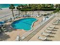 Aerial view of a sparkling pool with lounge chairs and umbrellas at a beachside condominium at 1586 Gulf Blvd # 2502, Clearwater, FL 33767