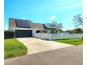 Charming home featuring a white fence, solar panels, and well-maintained landscaping at 1608 20Th W Ave, Palmetto, FL 34221