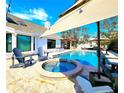 Gorgeous backyard with a pool, hot tub, pergola, and outdoor seating area at 1608 20Th W Ave, Palmetto, FL 34221