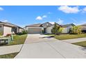 Charming single-story home with a well-manicured lawn and a two-car garage and mature landscaping at 16632 Sunburst Lake St, Wimauma, FL 33598