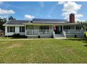 Charming single-story home featuring a welcoming front porch and solar panels for energy efficiency at 17430 Spring Valley Rd, Dade City, FL 33523