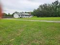 Charming single-story home with a covered porch and sprawling green lawn at 17430 Spring Valley Rd, Dade City, FL 33523