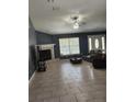 Open living room with tile floors, a fireplace, and a ceiling fan at 17430 Spring Valley Rd, Dade City, FL 33523