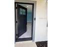 The open front door reveals the home's blue walls, recessed lights, and tiled flooring at 1762 Fulton Ave, Clearwater, FL 33755