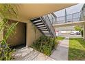 Exterior view of a condo complex featuring black iron stairs, green landscape, and ample parking at 1799 N Highland Ave # 3, Clearwater, FL 33755