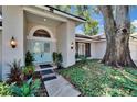Home with light blue double front doors, manicured landscaping, wall lanterns, and large shade tree at 1905 Horseshoe Dr, Plant City, FL 33566