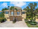 Inviting two-story home with a balcony, three-car garage, well-manicured landscaping, and a beautiful brick driveway at 191 Banyan Bay Dr, St Petersburg, FL 33705