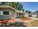 The exterior showcasing the entrance, and an attached garage, surrounded by a well-maintained yard at 1926 Fairway W Cir, Dunedin, FL 34698