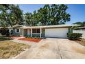 Charming single-story home featuring a well-maintained front yard and an attached garage at 1926 Fairway W Cir, Dunedin, FL 34698