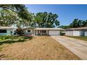 Charming single-story home featuring a well-maintained front yard and a convenient attached garage at 1926 Fairway W Cir, Dunedin, FL 34698