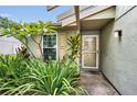 Close-up of a charming front entrance with well-maintained landscaping and a decorative storm door at 204 Lake Charles Ct, Oldsmar, FL 34677