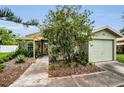 Inviting home exterior with a well-kept lawn, mature landscaping, and covered entry way at 204 Lake Charles Ct, Oldsmar, FL 34677