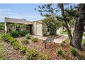 Quaint single-Gathering home with lush landscaping, a garden bench, and covered entryway at 204 Lake Charles Ct, Oldsmar, FL 34677