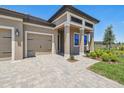 Inviting home facade showcasing a paver driveway, a two car garage, and a covered portico entry at 2603 Wise River Ln, Zephyrhills, FL 33541