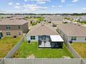 Aerial view of backyard featuring fenced yard with screened patio in a residential neighborhood at 33716 Elm Hill Br, Wesley Chapel, FL 33545